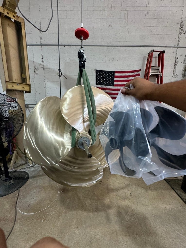 Person holding a clear plastic bag next to a suspended clear dome-shaped object in a garage with an American flag on the wall