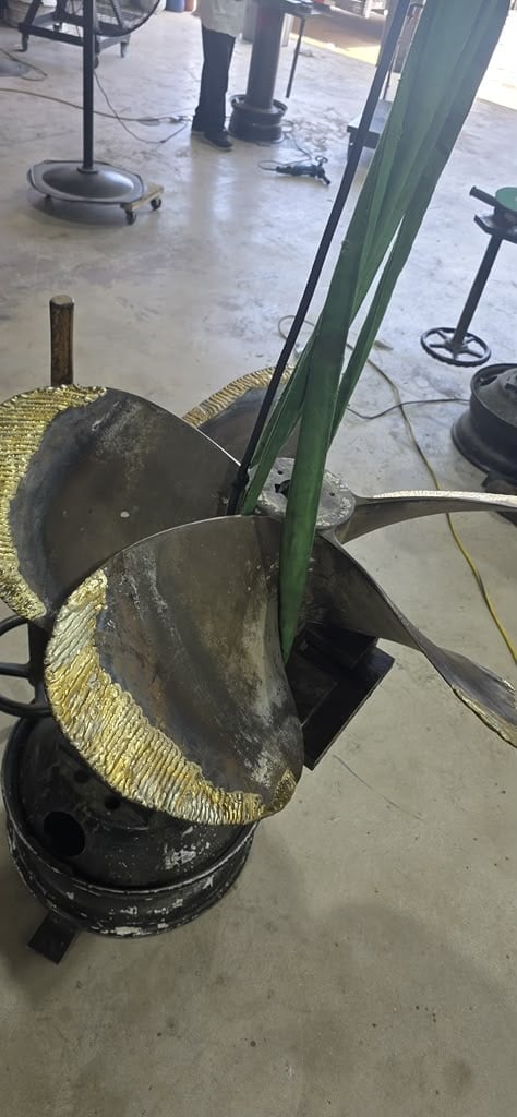 Industrial workshop with large cutting discs and metal equipment mounted on green pole, concrete floor visible