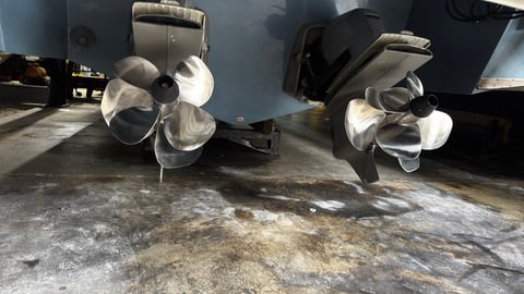 Two large white industrial fans mounted under black cargo vehicles on a concrete surface