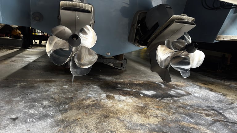 Two large white industrial fans mounted under black cargo vehicles on a concrete surface