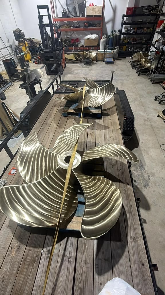 Neon sign sections shaped like guitar body parts laying on wooden trailer in industrial workshop